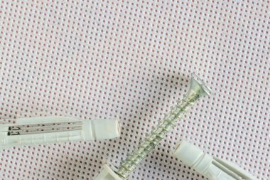 Plastik duvar tıkaçları ve metal vida donanım ve tamir araçlarını temsil ediyor