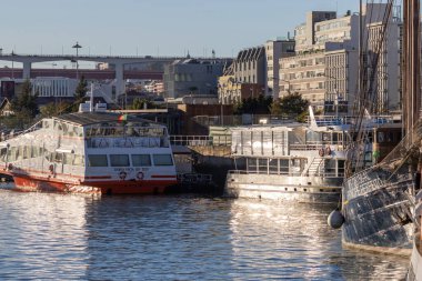Alcantara rıhtımında demirlemiş tekneler belediye binaları ve arka planda bir köprü var.
