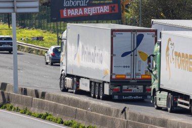 Lojistik ve küresel taşımacılığı betimleyen yoğun bir otoyol boyunca hareket eden kamyonlar ve arabalar