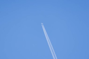 Açık mavi gökyüzünde uçan uçaklar beyaz bir iz bırakır.