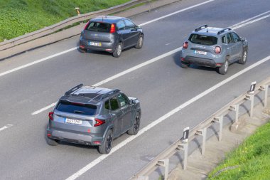Hava perspektifinden asfalt yolda giden araçlar, trafik akışını gösteriyor
