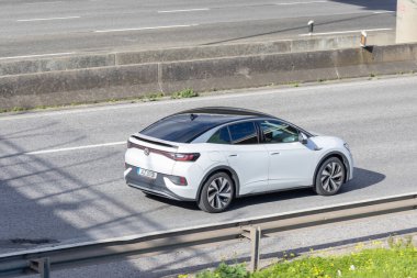 Volkswagen id.5 elektrikli SUV modern E hareketliliğini temsil eden çok şeritli bir otoyolda gidiyor.