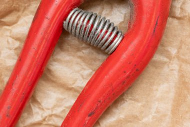 Kırmızı metal fındıkkıran, bahar mekanizmasını buruşuk kahverengi kağıtta gösteriyor.