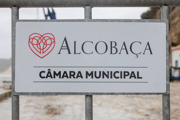 obidos Castle featuring ancient stone walls, an information sign, and traditional paving
