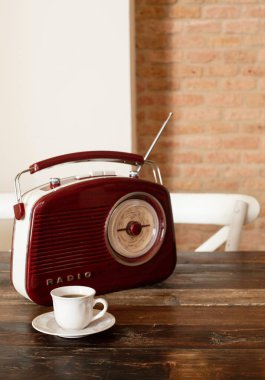 Mutfaktaki ahşap bir masanın üzerinde retro tarzında bir kahve ve bir radyo var..