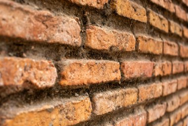 Uzağa uzanan eski bir tuğla duvar..