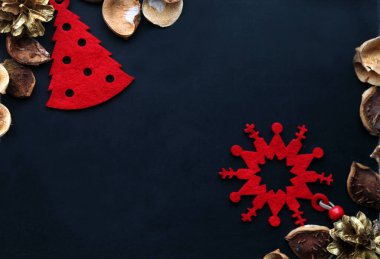 Keçe, altın koniler ve kestanelerden kırmızı süslemeli Noel kompozisyonu. Boşluğu kopyala.