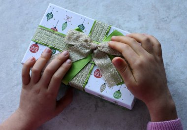 Hediye kutusunu tutan eller. Üst görünüm.