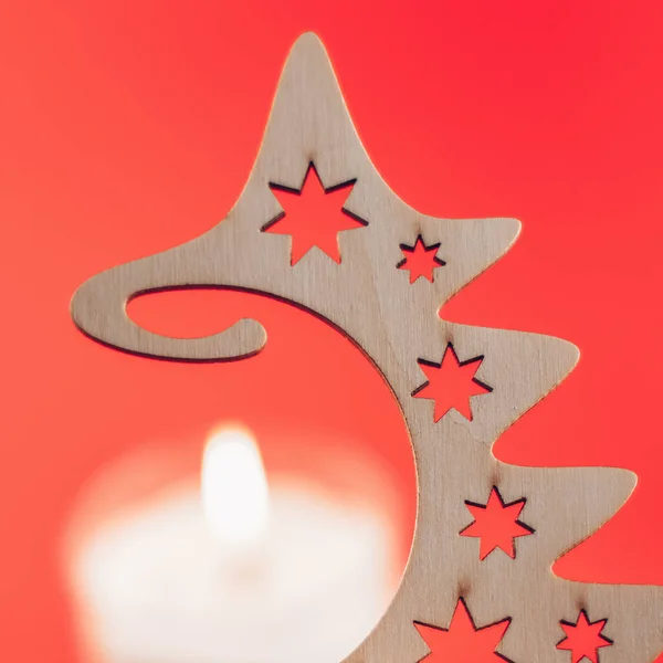 Mum ışığında ahşap Noel ağacı ve kırmızı arka plan, kartpostal deseni