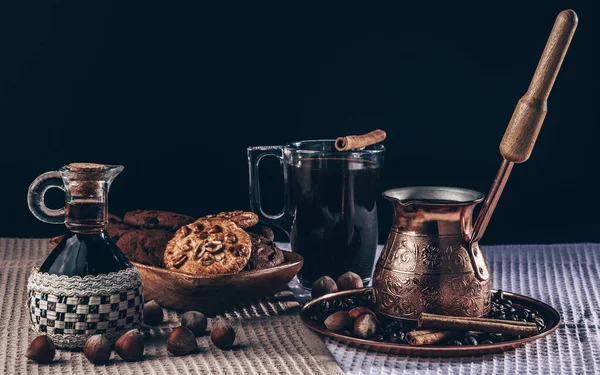 Kahve hala hayat, bakır kafeste kahve cam bardakla, kahvaltıda kurabiye ve fındık.