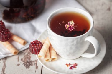 Çilek ve gofret şeklinde marmelatlı bir fincan meyve çayı.
