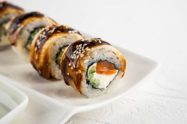 Suşi ruloları yılan balığı, somon, peynir, salatalık, beyaz arka planda yakın çekim.