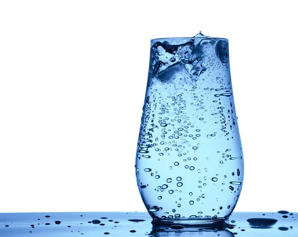 Buz küpleri, kabarcıklar ve damlacıklarla izole edilmiş bir bardak soda soda.