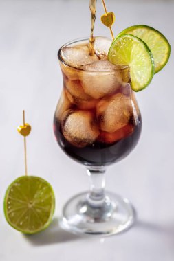 Kola ve limonlu taze alkollü kokteyl, buzlu cam, yakın çekim ve seçici odaklanma.