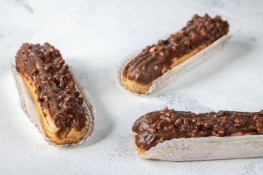 Beyaz arka planda üç çikolatalı ekler, seçici odak