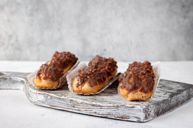 Eski ahşap tahtada üç çikolatalı ekler, metin için boş alan.