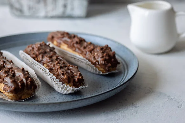 Három Eclair Kék Tányéron Tejszín Szürke Alapon — Stock Fotó