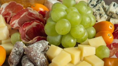 Jambon peynirli ve üzümlü şarküteri tahtası. Arka planı kapat, seçici odaklı yemek arkaplanı.
