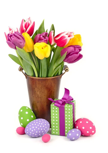 Bright spring tulips in a bucket and Easter eggs on a white background with the place for the text. — Stock Photo, Image