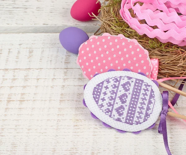 Os ovos bordados decorativos de Páscoa em paus em um contexto de madeira leve. Fundo de Páscoa com espaço para o texto . — Fotografia de Stock