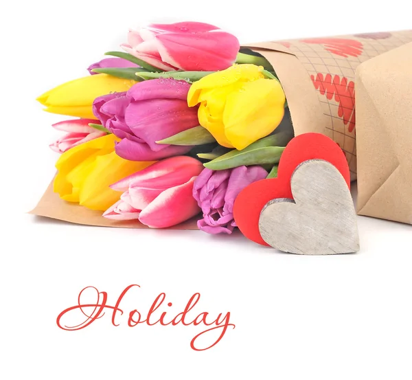Bright spring tulips and hearts on a white background with space for the text. — Stock Photo, Image