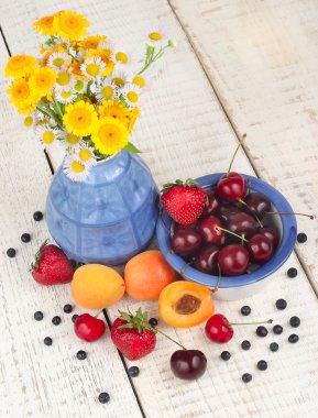 Taze çilek ve camomiles metin için yer beyaz bir ahşap zemin üzerine vazo.