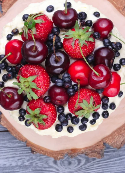 Sommer-Keks-Kuchen mit Mascarpone-Creme und frischen Beeren auf einem hölzernen Hintergrund. Ansicht von oben. — Stockfoto