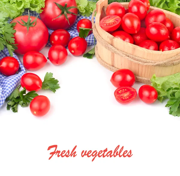 Frische Tomaten und Kirsche und Grüntöne auf einer blau karierten Serviette auf weißem Hintergrund mit Platz für den Text. — Stockfoto