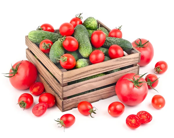 Wooden box with fresh cucumbers and tomatoes on a white background with space for the text. — Stock Photo, Image