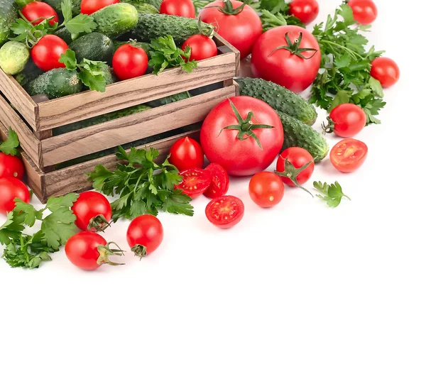 Tomates frescos e pepinos em uma caixa de madeira em um fundo branco com espaço para o texto . — Fotografia de Stock