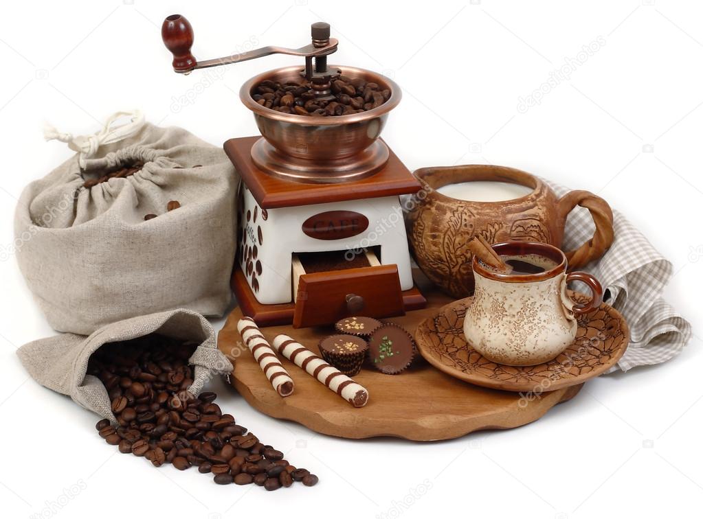 The coffee grinder and cup of coffee on a white background.
