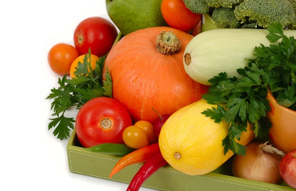 Verduras frescas en una caja verde sobre un fondo blanco . — Foto de Stock