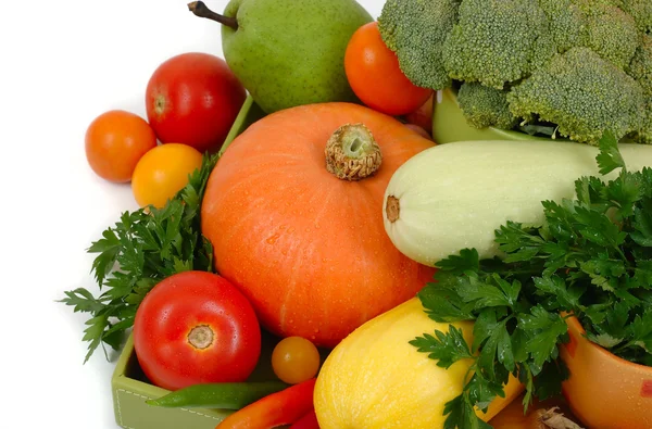 Légumes frais dans une boîte verte sur fond blanc . — Photo