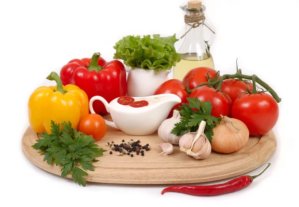 Fresh vegetables and sauce in a sauce-boat on a white background. — Stock Photo, Image