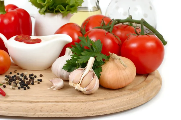 Fresh vegetables and sauce in a sauce-boat on a white background. — Stock Photo, Image