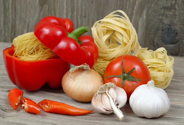 Pâtes et légumes frais sur fond de bois . — Photo