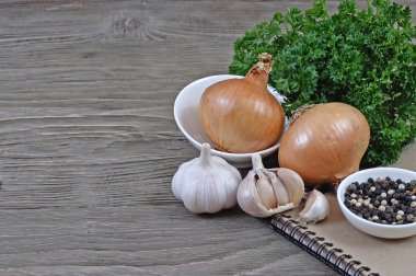 Sarımsak ve soğan ahşap arka plan üzerinde bir dizüstü.