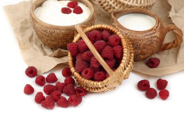 Beyaz zemin üzerinde bir sepet içinde ahududu.