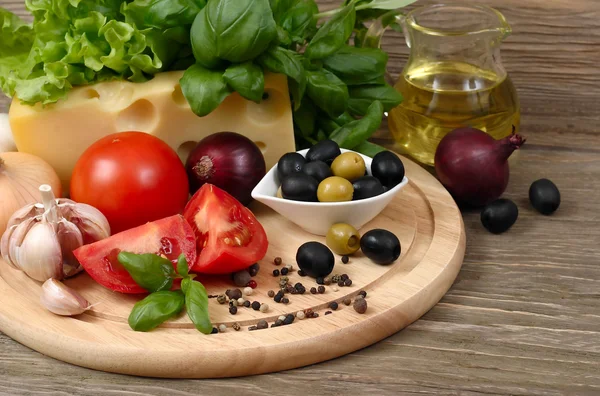 Fresh vegetables and cheese on a wooden background. — Stock Photo, Image