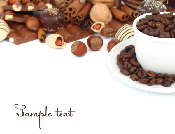 Cup with coffee grains and praline chocolate on a white background. — Stock Photo, Image