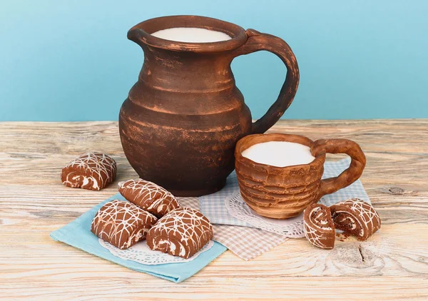 Milk in a jug and cookies on a wooden background. — Stock Photo, Image