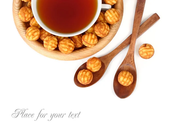 Tasse Tee und Kekse auf einem Holzteller auf weißem Hintergrund. Ansicht von oben. — Stockfoto