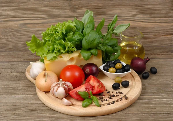 Fresh vegetables and cheese on a wooden background. — Stock Photo, Image