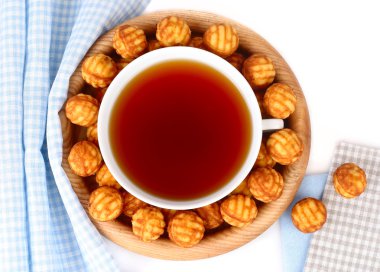 Bir fincan çay ve Bisküvi Kurabiye beyaz bir arka plan üzerinde ahşap bir tabakta da. Üstten Görünüm.