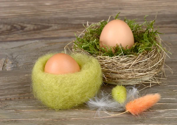 Easter eggs in a nest on wooden a rustic a background. — Stock Photo, Image