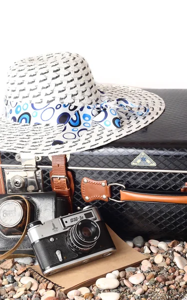 Eski bavul, kamera ve beyaz zemin üzerine şapka. Retro seyahat. — Stok fotoğraf