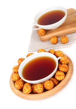 Fincan çay ve bir ahşap plaka beyaz bir arka plan üzerinde yuvarlak Bisküvi Kurabiye.