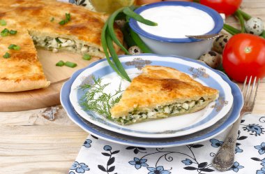 Taze pişmiş ev pasta yumurta ve yeşil soğan o Ayrıca bir retro uzak süpürüldü bir doldurma ile bir rustik bir arka plan üzerinde ahşap plakalar.