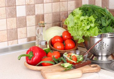 Bir kevgir ve modern mutfak karşı doğrama tahtası kesme sebze taze bitik sebze.