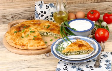 Taze pişmiş ev pasta yumurta ve yeşil soğan o Ayrıca bir retro uzak süpürüldü bir doldurma ile bir rustik bir arka plan üzerinde ahşap plakalar.